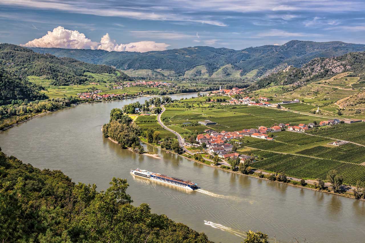 Panorama of the Wachau Valley with tourist ship sailing the Danube towards the village of Duernstein in Lower Austria