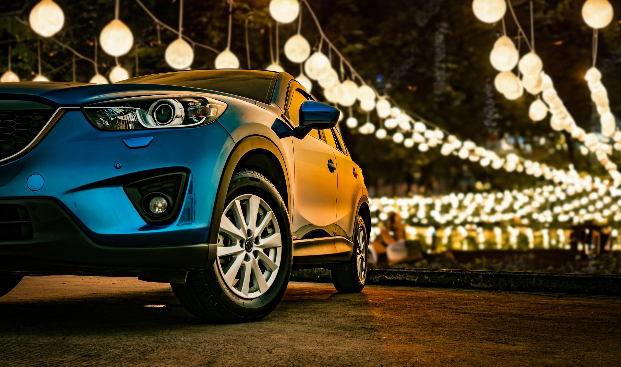 Closeup of car with a lights festival background