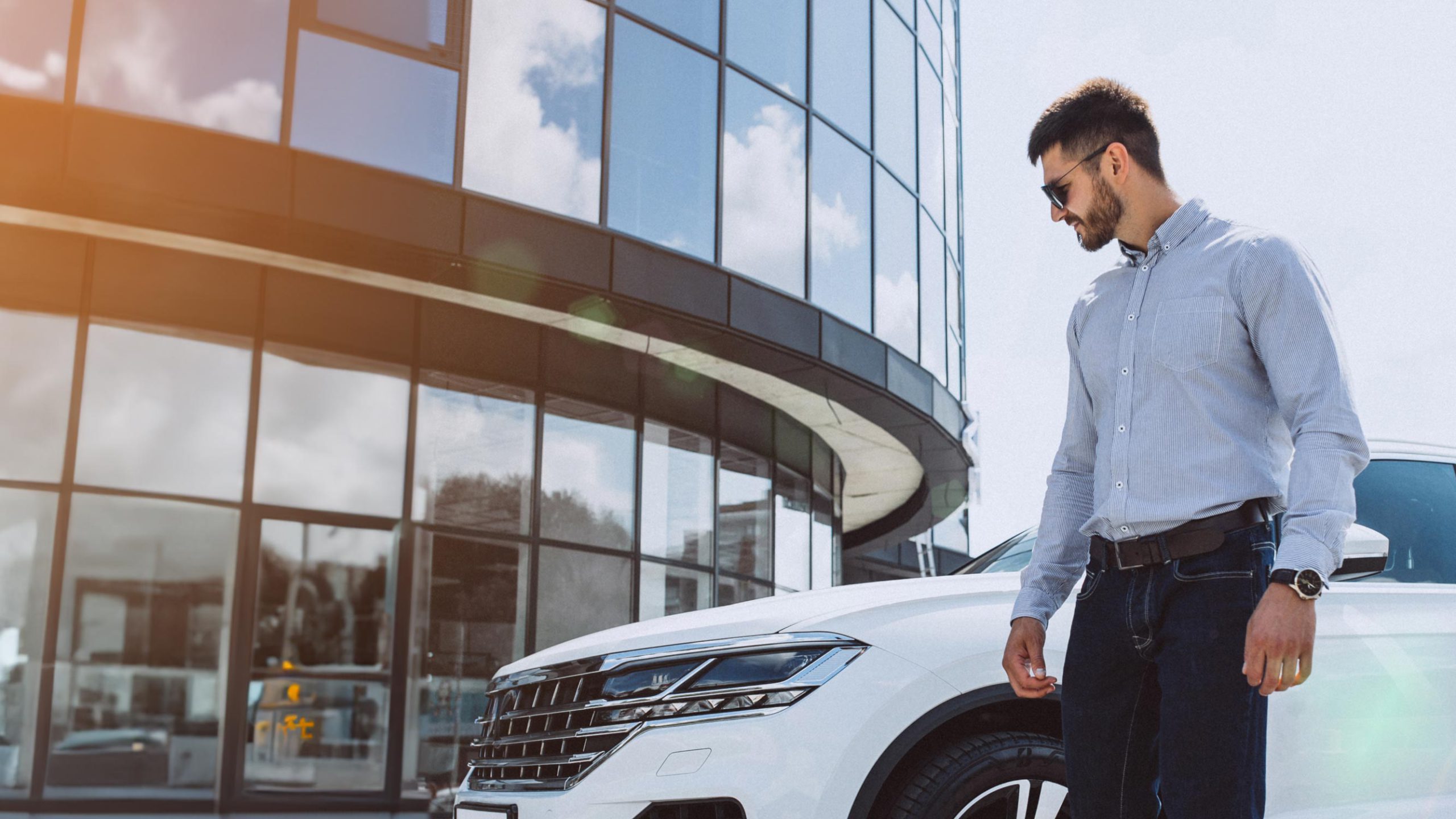 Businessman in front of a white car