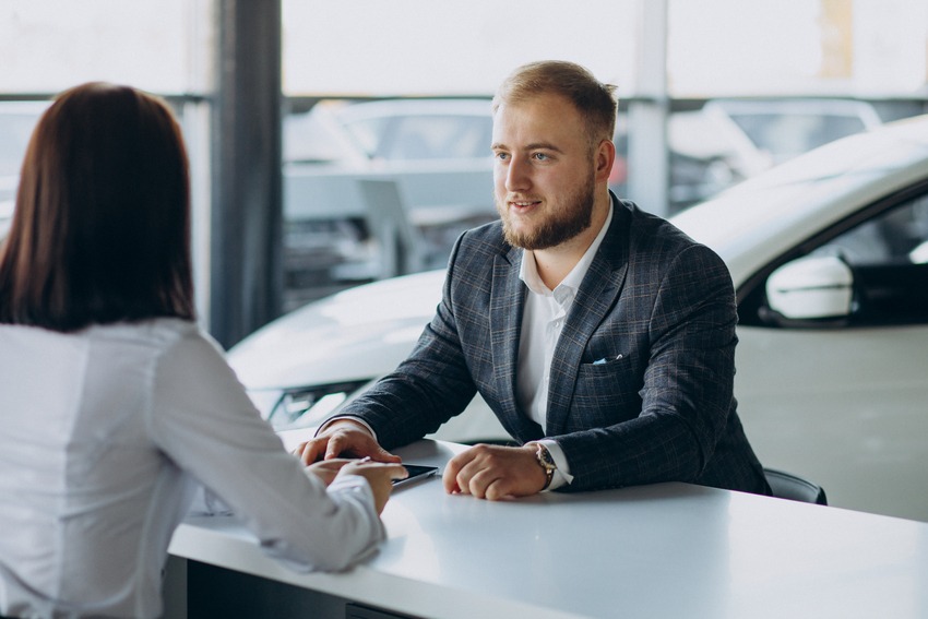 Man talk with client in car rental showroom