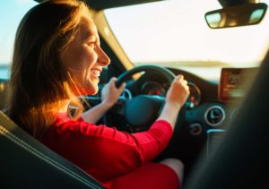 Happy woman driving a car
