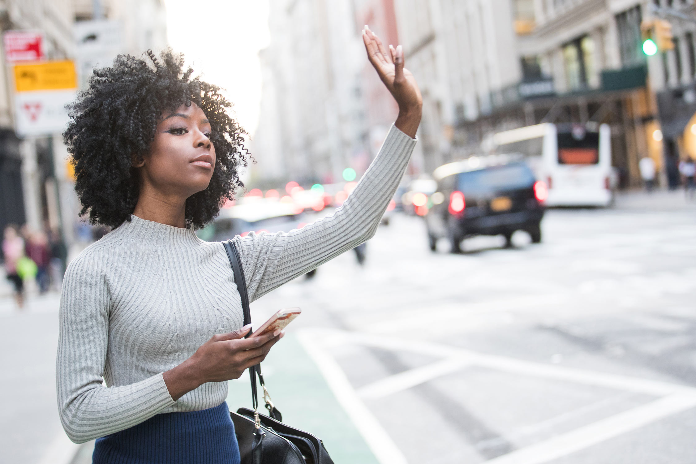 Woman hailing taxi cab or ride share car service in New York