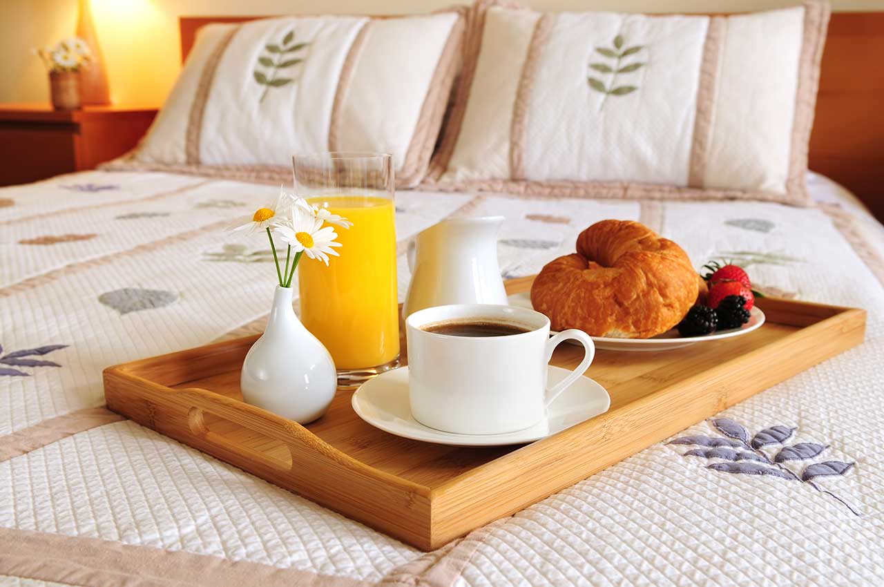 Tray with breakfast on the bed of a hotel room