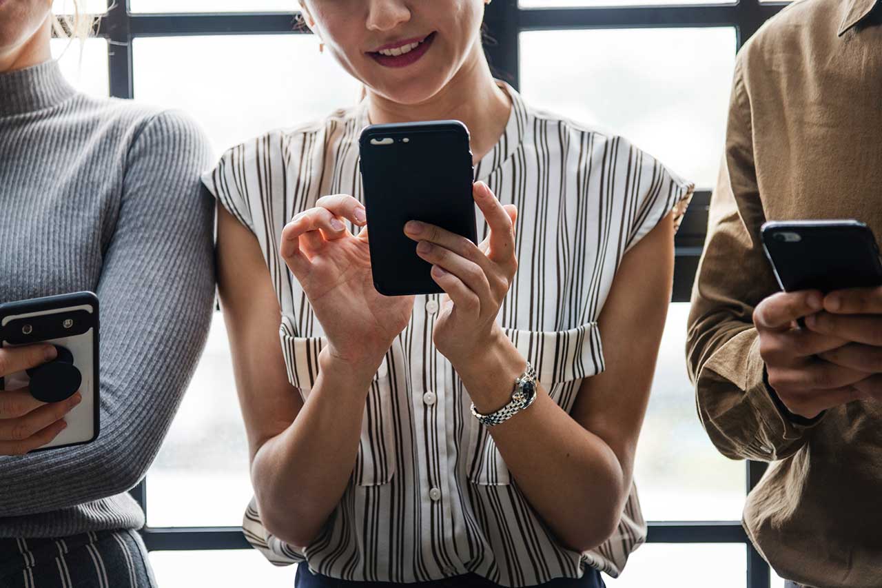 Smiling woman uses her smartphone
